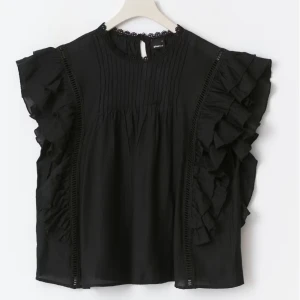 Mini boho frill top Black - Supersnygg svart blus med volanger längs ärmarna och fina spetsdetaljer vid halsen. Från Gina Tricot, original pris 399,95kr OANVÄND