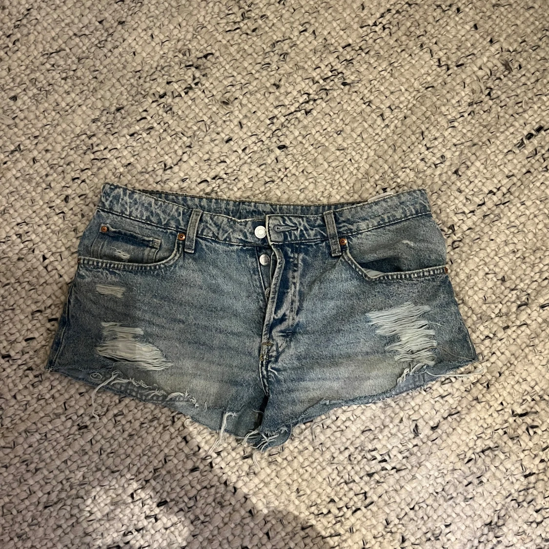 Blå jeansshorts med slitningar