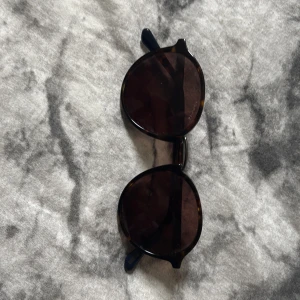 ÄKTA Bruna runda solglasögon från Gant - Snygga solglasögon från Gant med runda, bruna glas och klassisk sköldpaddsmönstrad båge. Nypris: runt 2000. Perfekt accessoar för att lyfta din stil under soliga dagar. Bågarna har en tidlös look och passar till de flesta outfits. Obs ena bågen är lite slapp men märks inte när dem är på.