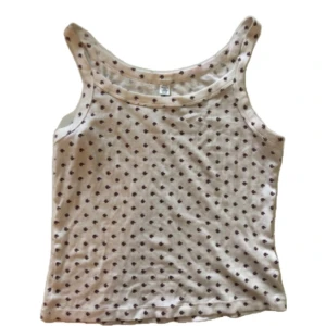 Vit blommig linnetopp - Supersöt vit linnetopp med små blommönster över hela. Topp med klassisk rak passform och breda axelband, perfekt för varma dagar. Mjuk och skön bomullskänsla som gör den enkel att matcha till jeans eller kjol.