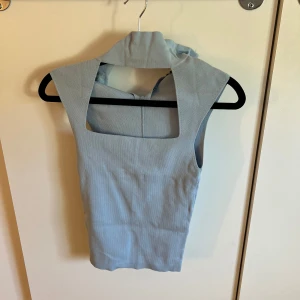 Ljusblå ärmlös linnetopp - Snygg ljusblå linnetopp med fyrkantig urringning och breda axelband. Toppen är ärmlös och har en stilren, minimalistisk design som passar perfekt till jeans eller kjol. Storlek S