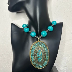Maxat vintagehalsband med turkoser & stort  turkost mosaikhänge – boho 70-tal retro  - Stort vintagehalsband i bohostil med turkosfärgade pärlor och ett maffigt hänge i antikguldig metall med mosaik i rekonstruerad turkos – ett material gjort av sammanpressade turkosbitar och harts, vanligt i 70–80-talets smycken. Längd ca 70 cm. Hänget är ca 9 x 5,5 cm. Ett riktigt statementsmycke som drar blickarna till sig.  Ingen prutning – men jag erbjuder bundlerabatt. Kika gärna på mina andra annonser också, jag rensar smyckesskrinet!  