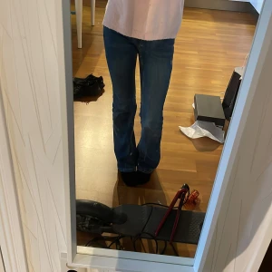 Blå bootcut jeans från ONLY - Säljer ett par klassiska blå bootcut jeans från ONLY. Jeansen har normal passform, fem fickor och snyggt utsvängda ben. Tillverkade i mjukt denimtyg med lite stretch för extra komfort. Perfekta till sneakers eller boots. Dom är i bra skick men är lite slitna nere vid benen. Nytt pris är 500