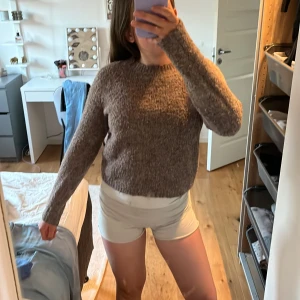 Brun stickad tröja - Mysig brun stickad tröja med rund halsringning och lång ärm. Perfekt för kyligare dagar och enkel att matcha med olika outfits. Tröjan har en klassisk, rak passform och är gjord i ett mjukt material.