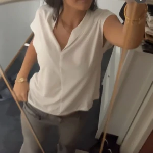 Vit blus med v-ringning - Säljer en stilren vit blus med v-ringning och korta ärmar. Perfekt för dig som gillar en enkel men snygg look. Blusen har en lös passform och är tillverkad i ett mjukt material.