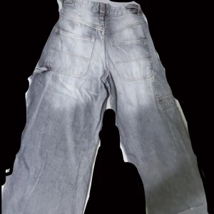 Gråa wide jeans med stora bakfickor - Säljer ett par gråa jeans med bred passform och stora bakfickor. Byxorna har normalhög midja och raka, vida ben. Perfekta för en avslappnad och trendig stil. Har använt de bara 1 gång. Säljer de för att de passar inte mig så bra