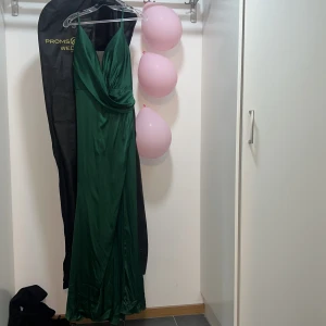  Grön långklänning från Cinderella Divine. Fest klänning - Säljer en elegant grön långklänning från Cinderella Divine. Klänningen har en v-ringad design med smala axelband och är tillverkad i glansig polyester. Perfekt för speciella tillfällen!👗Fest klänning, jätte dyr, denna klänningen blev skapats av en professionell. Priset kan diskuteras. Använt 1 gång bara och den var liten för mig. Storlek:  S 