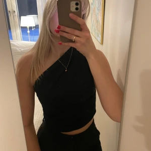 Svart oneshoulder topp - Snygg svart oneshoulder topp som stängs med en dragkedja på sidan. Superfin till kostymbyxor eller kjol eller jeans och klackar 😍