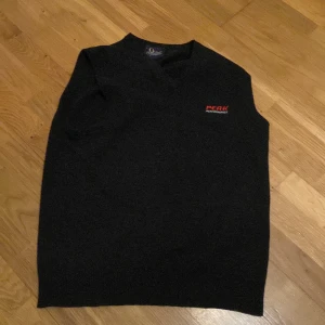 Mörkgrå ullväst från Peak Performance - Säljer en stilren mörkgrå ullväst från Peak Performance. Västen är tillverkad i 100% lammull och har en diskret logga på bröstet. Perfekt för att hålla värmen med stil. 🐑