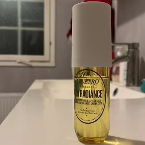 Rio Radiance från Sol de Janeiro - Fräsch och exotisk parfymmist från Sol de Janeiro, Rio Radiance. Flaskan är genomskinlig med en vit spraykork och rymmer 90 ml. Doften har inslag av kokosmjölk och tropiska toner, perfekt för en somrig känsla.