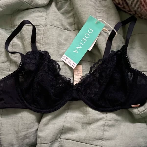 Dorina Origins Non Padded Wired Bra - ”Dorina Origins Non Padded Wired Bra” i storlek 75A. Helt ny och oanvänd med etiketten kvar. Elegant och bekväm design i klassiskt svart, perfekt för en naturlig och smickrande passform. Inköpt online, säljes då storleken inte passade.