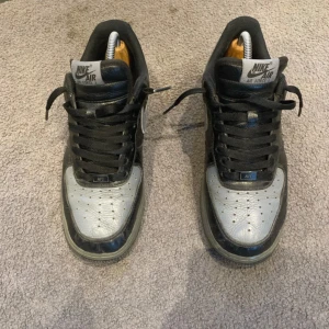 Nike Air Force i svart och grått - Hej! Säljer nu dessa customized af1 i helt okej skick. De är välanvända. Finns defekter på sista bilden. De är köpta från Nike för 1599. Har ingen box kvar för jag kastade den när jag fick de. Skriva gärna vid någon fundering!