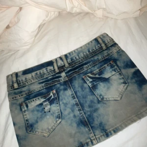 Jeanskjol från Yiqinier jeans - Snygg jeanskjol från Topshop i en cool tvättad look. Kjolen har slitna detaljer framtill och klassiska femficksdesign. Perfekt för en avslappnad stil. Står 29 i men den är liten i storlek, midjemåttet rakt över är 42cm💖