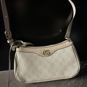 Beige axelväska med gulddetaljer - Fin väska 