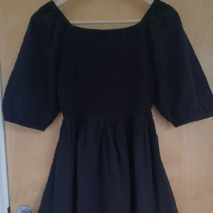 Svart klänning från Kappahl - Säljer en svart klänning från Kappahl i 100% bomull. Klänningen har en minimalistisk design med korta ärmar och en bekväm passform. Liten i storleken, passar tjejer med storlek 158😚💗💫