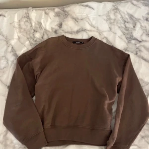 Brun sweatshirt från bikbok  - Säljer en brun sweatshirt från bikbok. Tröjan har en klassisk rund halsringning och långa ärmar. Perfekt för en avslappnad stil.