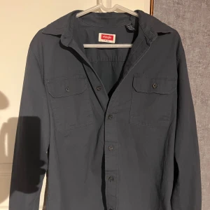 Mörkblå overshirt från Wrangler - Overshirt från Wrangler| Storlek:M | Använd ett fåtal gånger |Nypris: 499 mitt pris: 299| Hör av dig vi minsta fundering. 