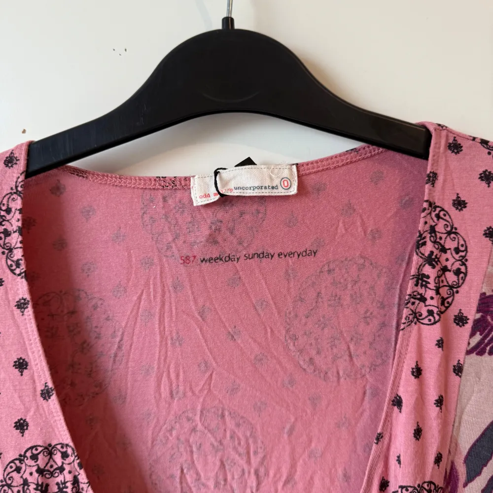 Säljer en rosa klänning med ett unikt mönster i mörkare nyanser. Klänningen har en v-ringad design och korta ärmar med fransdetaljer. Den har även ett knytband i midjan för en snygg passform. Från märket Odd Molly i storlek 0 som enligt deras storleksguide motsvarar en XS. Mycket fint skick, jag hittar inga synliga anmärkningar eller defekter. . Mekot.