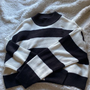 Randig svart och vit tröja - Säljer en stilren svart och vit randig tröja med långa ärmar. Tröjan har en klassisk design med breda ränder och en bekväm passform. Perfekt för en avslappnad look.