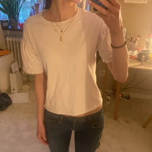 Ljusrosa  blus från Zara - Säljer en söt ljusrosa blus från Zara med puffiga kortärmar. Perfekt för en stilren och enkel look. Blusen har en rund halsringning och är tillverkad i ett mjukt material.