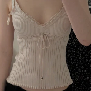 Rosa ribbad topp med spetsdetaljer - Säljer en Isabell kristensen rosa ribbad topp med spetsdetaljer vid bysten. Toppen har en v-ringad design och är perfekt för varmare dagar. Den har en fin struktur och en feminin touch med spetsen. Väldigt stretchig