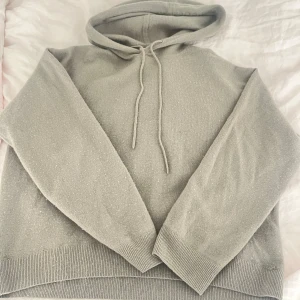 Hoodie  - Säljer en snygg grå hoodie av cashmere. Den har en klassisk huva med dragsko och långa ärmar. Strl s men snarare en Xs, fint skick
