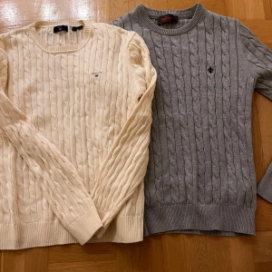 Beige och grå kabelstickade tröjor - Två stilrena kabelstickade tröjor i beige och grått. Den ena från Morris i storlek XS och den andra från Gant i storlek 176. Båda är dock lika stora. 