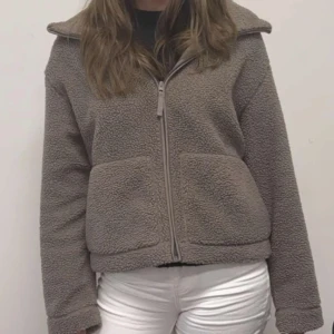 Beige teddyjacka med dragkedja - Mysig beige teddyjacka med dragkedja framtill. Jackan har långa ärmar och en bekväm passform, perfekt för kyligare dagar. Den har en enkel design med två fickor framtill. Skriv gärna innan köpes💞