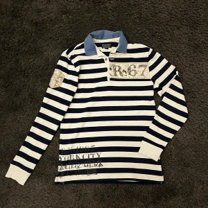 Långärmad Ralph Lauren pike  - Riktigt fet randig långärmad Ralph Lauren pike med detaljer som gör den väldigt unik och perfekt till sommaren då den ger lite mer av en båt/seglar vibe, passar perfekt till ett par mörkblåa loafers till exempel. Storlek S och sitter väldigt bra 