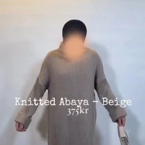 Beige stickad abaya - Säljer en stilren beige stickad abaya med lång ärm. Perfekt för kyligare dagar med sin mjuka och bekväma passform. Ett mångsidigt plagg som kan stylas på olika sätt.
