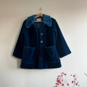 Faux fur kappa, Bik Bok X Elsa Hosk - Säljer en snygg blå pälsjacka från Bik Bok i storlek XS. Jackan är supermjuk och fluffig med stora knappar framtill och två praktiska fickor. Obs översta senapen sitter lite löst men enkelt att återgärda. Bra skick!  