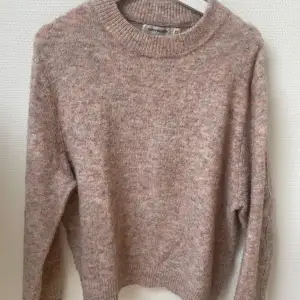 Mysig beige stickad tröja från Gina Tricot. Perfekt för kyliga dagar med sin mjuka och varma känsla. Tröjan har en rund hals och långa ärmar, vilket gör den idealisk för lager-på-lager-stil. Ett måste i garderoben för höst och vinter!