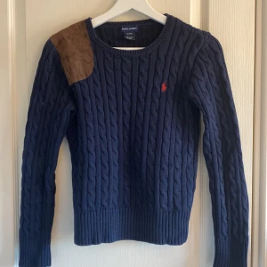 Ralph Lauren tröja  - Storlek Xs-S, marinblå med röd detalj och brun mocka axel. Kabelstickad och mycket bra skick