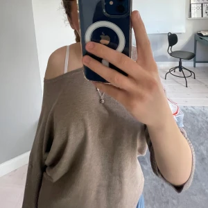 Brun offshoulder tröja - Säljer en snygg brun offshoulder tröja med trekvarts ärmar. Perfekt för en avslappnad stil. Tröjan har en mjuk och bekväm passform.