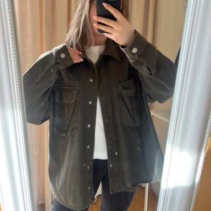 Olivgrön overshirt - Säljer en mörkgröna oversize jeansjacka från Zara med knappar och två stora bröstfickor. Jackan är använd några fåtal gånger och där med väldigt bra skick!