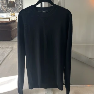 Crewneck - Säljer en stilren svart crewneck från Filippa K i 100% merinoull. Tröjan har en klassisk design med rund hals och långa ärmar, perfekt för en elegant och bekväm look. Den är i bra skick och sitter bra 