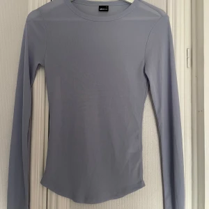 Ljusblå långärmad topp från Gina Tricot - Säljer en stilren ljusblå långärmad topp från Gina. Materialet är genomskinlig. Använd ca 2-3 ggn. Storlek S💕