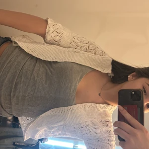 Vit stickad bolerotopp - Säljer en söt vit stickad bolerotopp med korta ärmar. Perfekt för att lägga till en extra touch till din outfit. Den har ett luftigt och bekvämt material som passar bra till både vardag och fest. Hör av er vid frågor!!!🩷