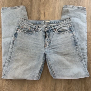 Ljusblå jeans från Gina Tricot - Säljer ett par ljusblå jeans från Gina Tricot. De har en klassisk femficksdesign och är tillverkade i denim. Byxorna har en rak passform och är högmidjade, vilket ger en snygg siluett. Perfekta för en avslappnad stil. INTE fri frakt