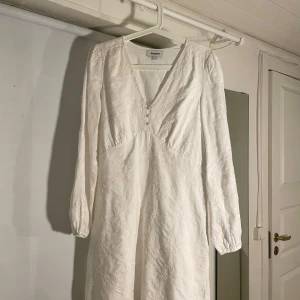 Vit student/konfirmations klänning från Kappahl - Säljer en vit klänning från Kappahl med broderade blommor och v-ringning. Aldrig använd. Klänningen har långa ärmar och en fin struktur i tyget. Perfekt för student, konfirmation och sommarens alla andra tillfällen! 