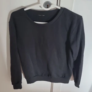 Svart tröja - Säljer en klassisk svart sweatshirt med rund hals och långa ärmar. Perfekt för en avslappnad stil och enkel att matcha med andra plagg. Passar både för vardag och mysiga hemmakvällar.