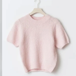 Ljusrosa stickad T-shirt - Säljer en söt ljusrosa stickad tröja med korta ärmar och rund hals. Perfekt för en mysig och stilren look. Från Gina och ändats testad. Storlek M men passar xs/s