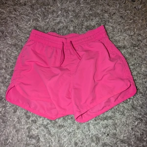 Rosa shorts med snörning - Snygga rosa shorts med elastisk midja och snörning. Perfekta för sommarens alla äventyr. De har en sportig look och är superbekväma att bära.