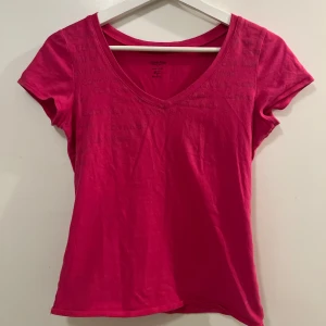 Rosa t-shirt från Calvin Klein - Säljer en snygg rosa t-shirt från Calvin Klein med v-ringning. Gjord i mjukt material och passar så bra på kroppen 