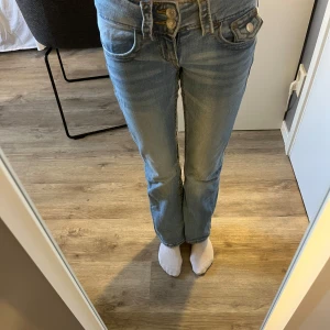 Blå jeans med bootcut och lowwaist - Snygga blå jeans med bootcut och låg midja. De har klassiska femficksdetaljer och knappar fram. Perfekta för en avslappnad stil.