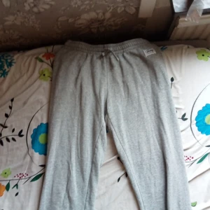 Grå mjukisbyxor från Frank Dandy - Säljer ett par grå mjukisbyxor från Frank Dandy. Byxorna har en elastisk midja och är perfekta för en avslappnad stil. De är tillverkade i ett mjukt material som ger en bekväm passform.