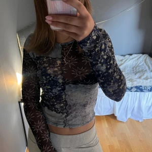 Mönstrad långärmad topp - Säljer en unik långärmad topp med ett mixat mönster i svart och blått. Toppen har en tight passform och är lite croppad.