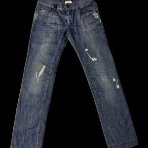 Dolce&Gabbana Jeans - Snygga blå jeans med slitningar från D&G. De har en klassisk femficksdesign och en rak passform. Perfekta för en casual stil. Storlek 48