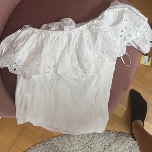 Vit oneshoulder topp med spetsdetaljer -  vit oneshoulder topp med spetsdetaljer och volang. Från Zara💓storlek 11-12 men passar mig som har xs oftast
