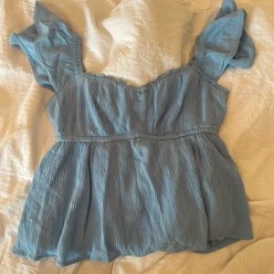Hollister Babydoll topp - Superfin och söt topp från Hollister som inte kommer till användning (aldrig använd)🥰 Den svarta på de sista bilderna är inte till salu utan enbart för att visa hur den sitter på! Köpte den för 369kr